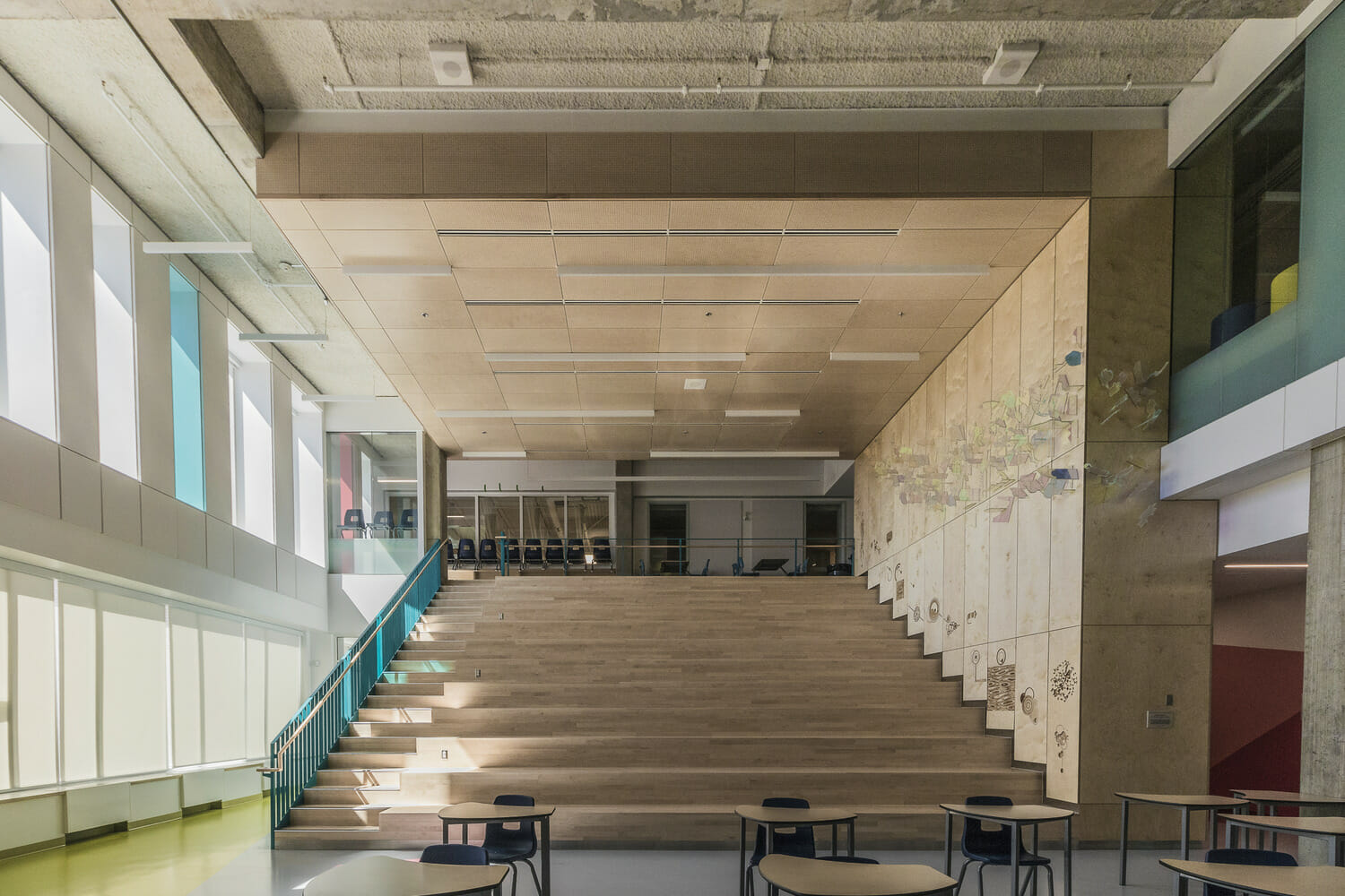 Un bâtiment scolaire avec des escaliers et des tables.