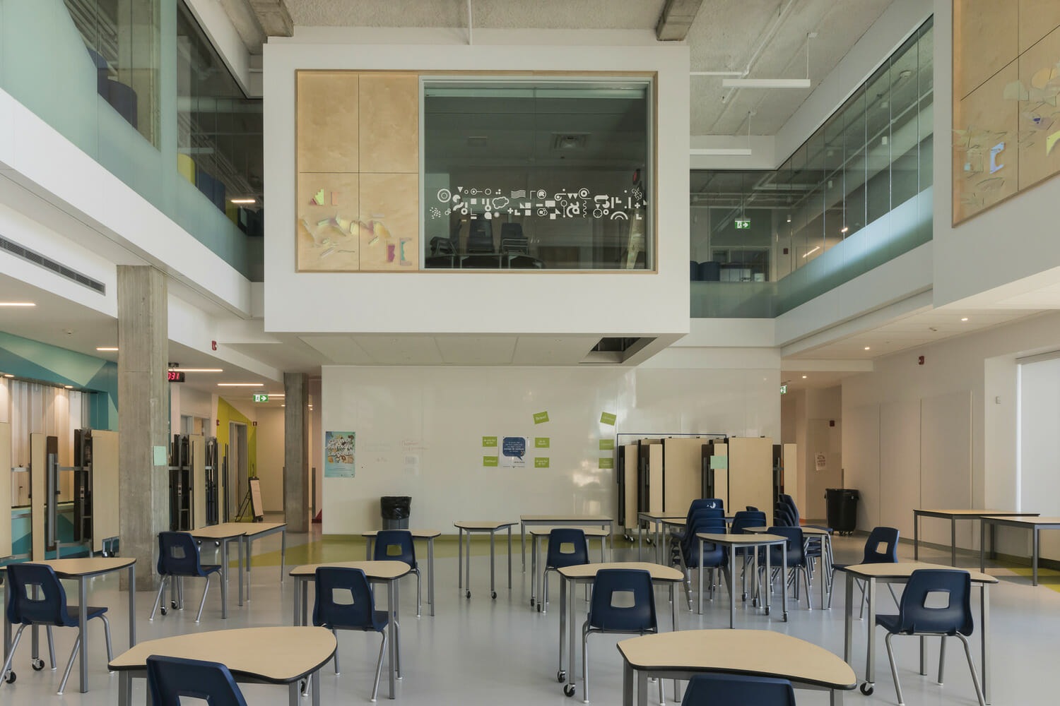 The interior of a classroom with tables and chairs.