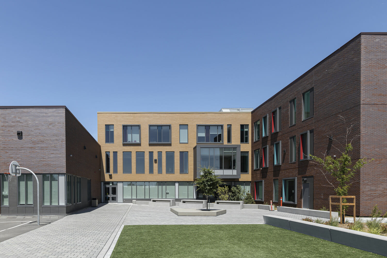 A courtyard with a brick building and a grassy area.