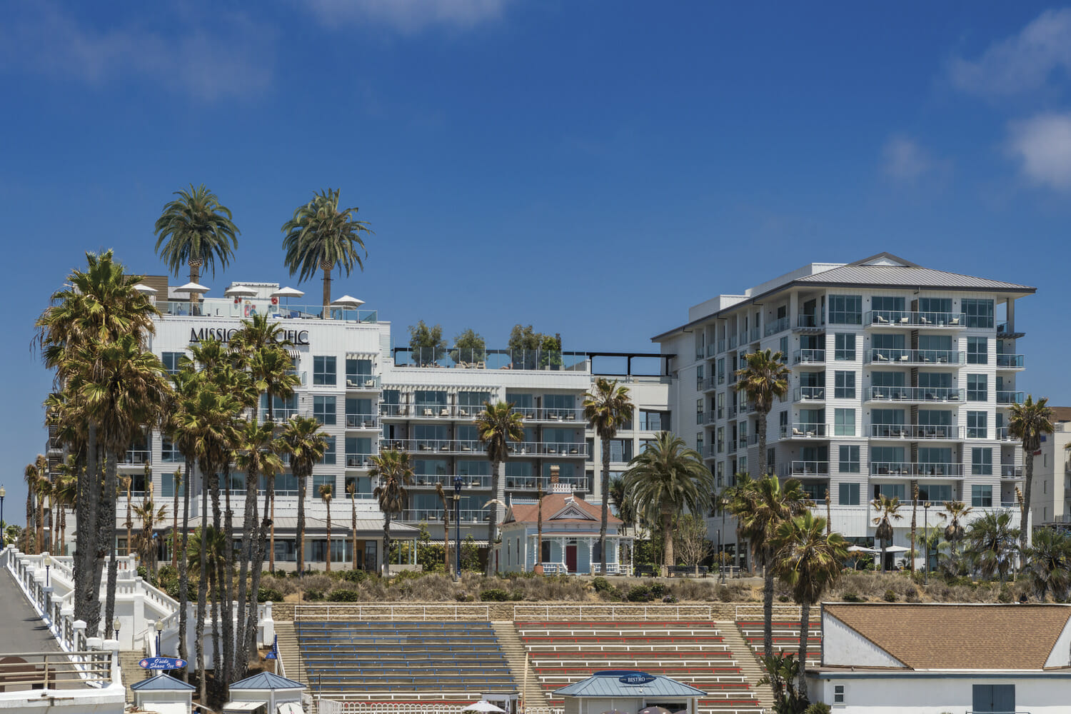 A white building with palm trees.