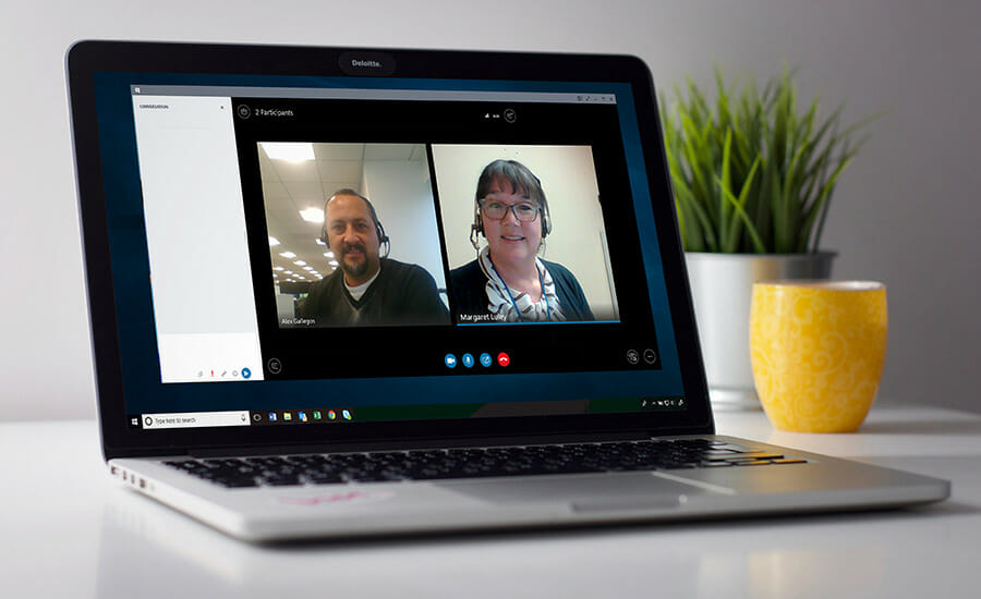 A laptop with two people on a video call.