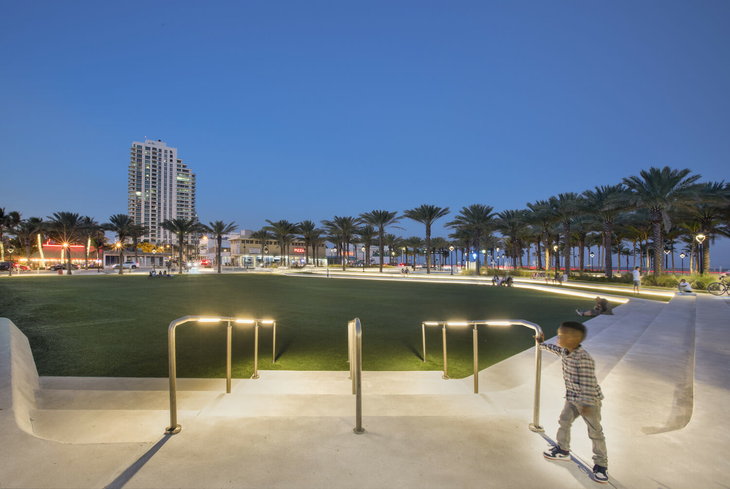 A young boy is skateboarding in a park at night.