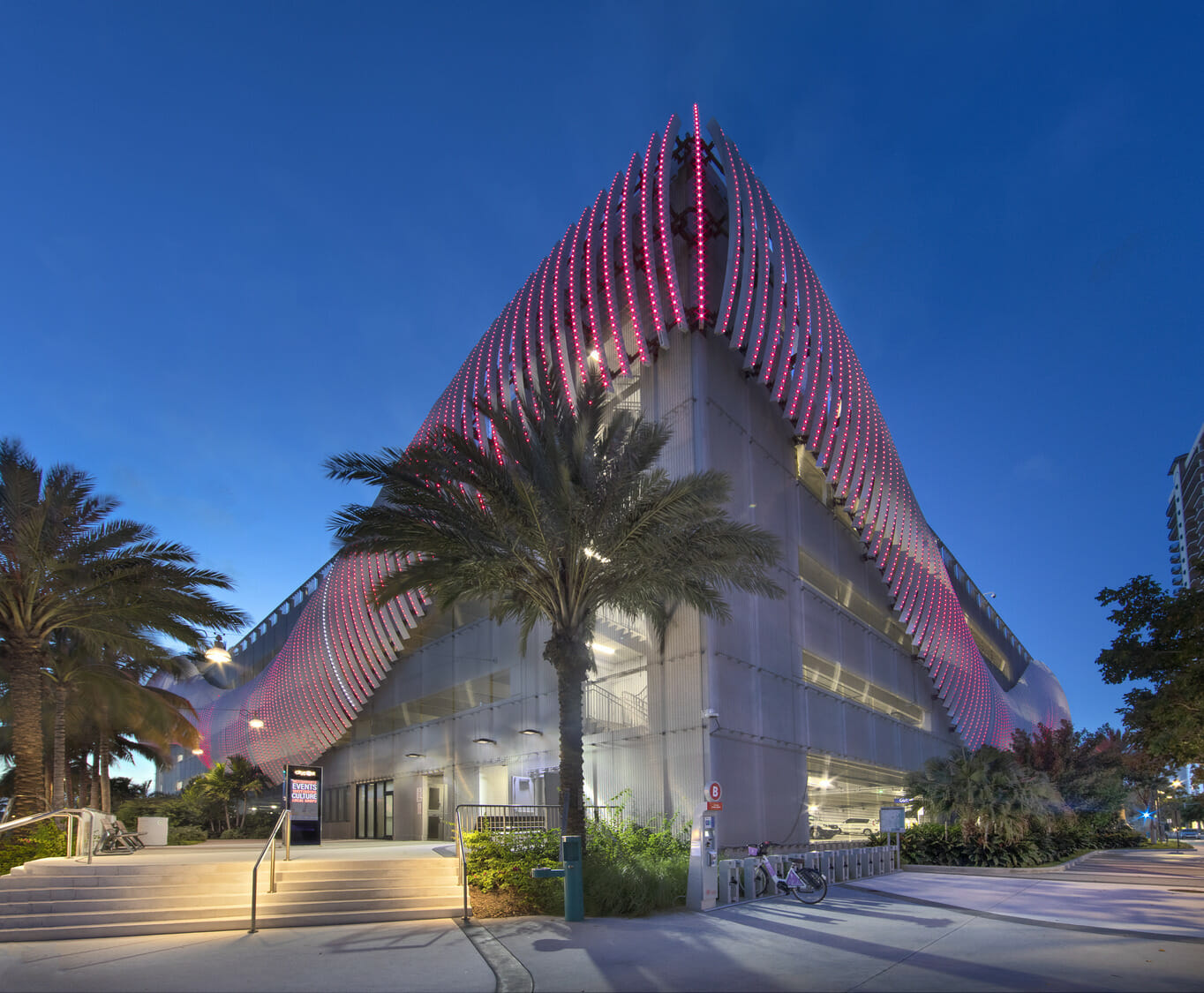 The building is lit up at night with red lights.