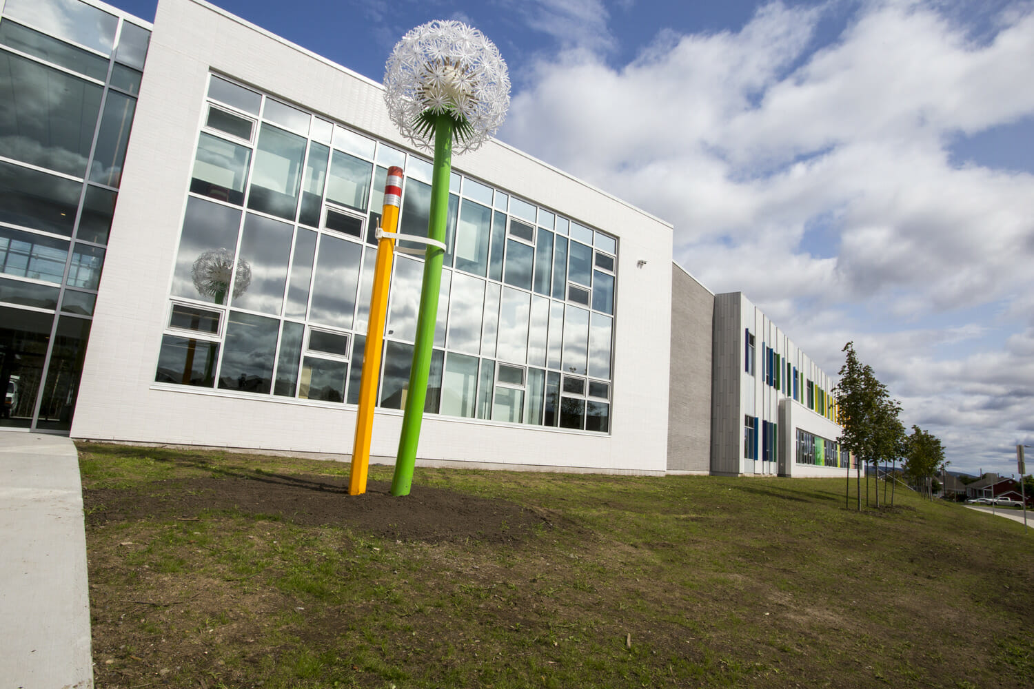 A large white building with a green grassy area in front of it.