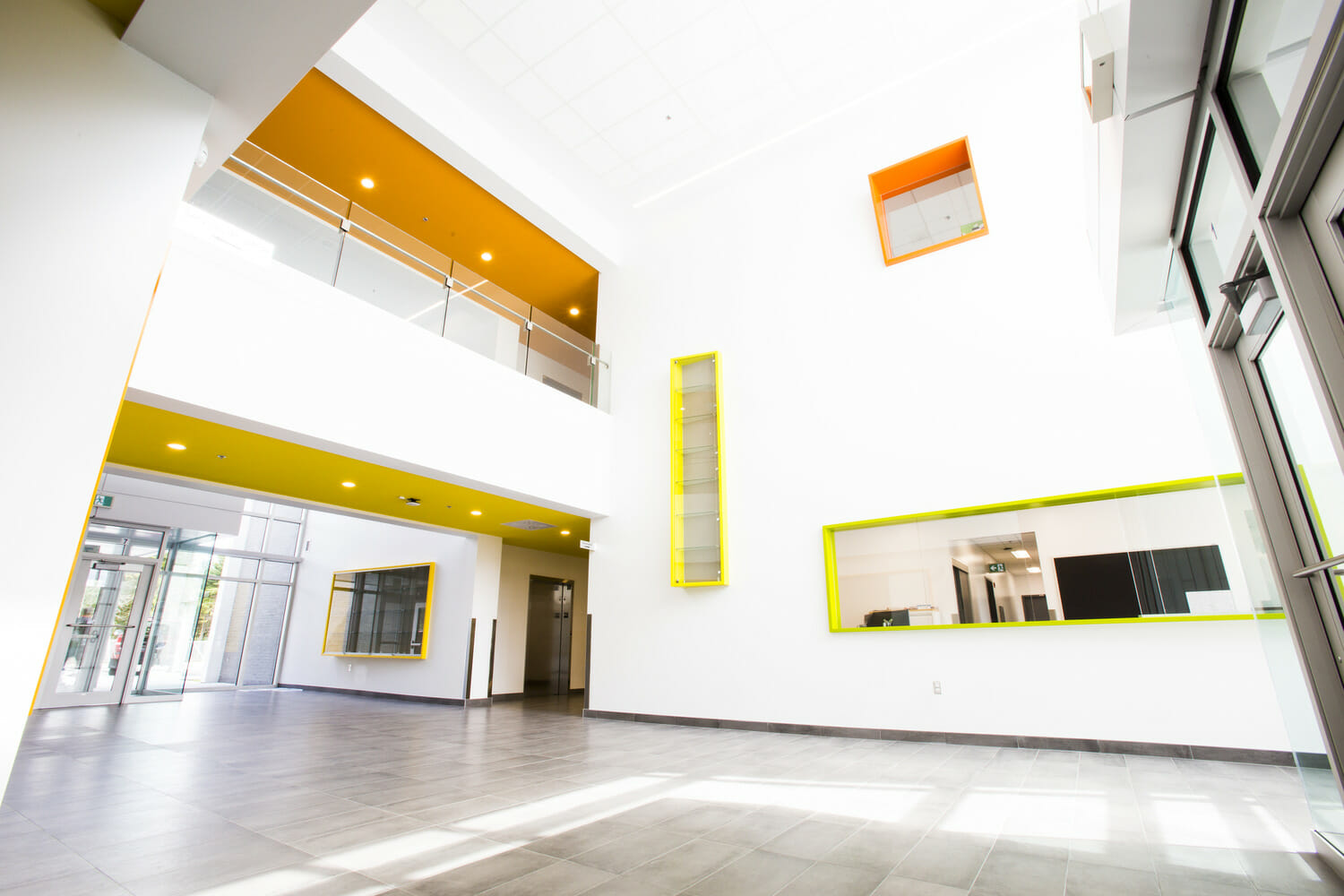Un couloir dans un immeuble aux accents jaunes et blancs.