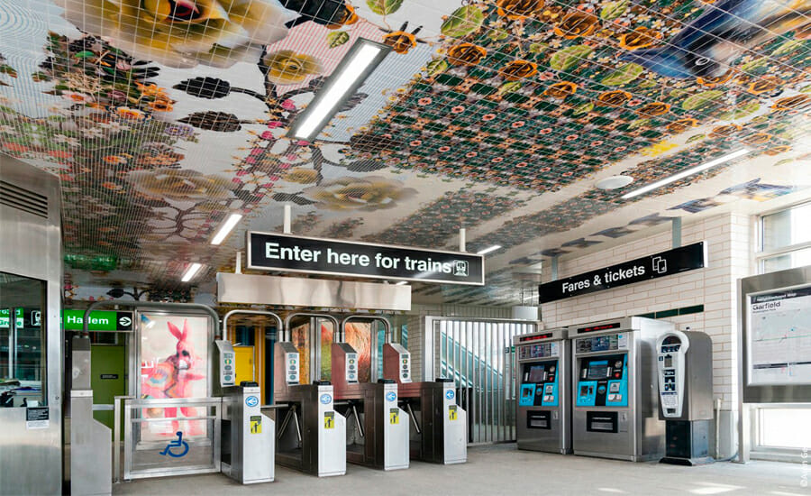 A subway station with a tiled ceiling.