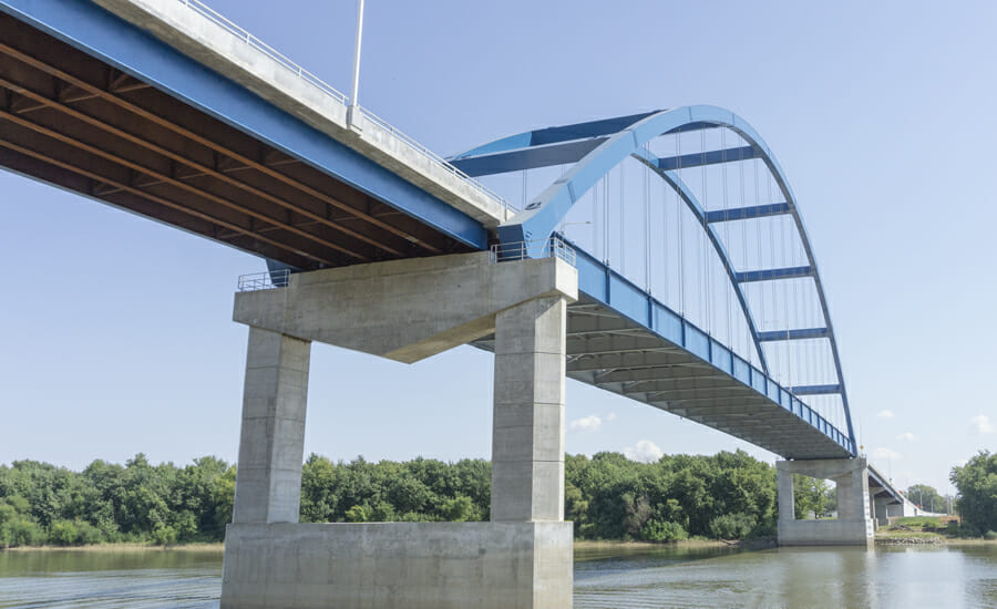 A blue bridge spanning over a body of water.