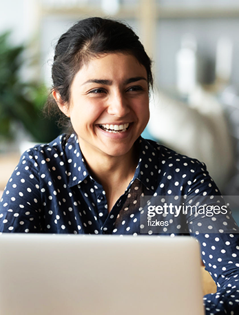 Une femme souriante utilisant un ordinateur portable à la maison.
