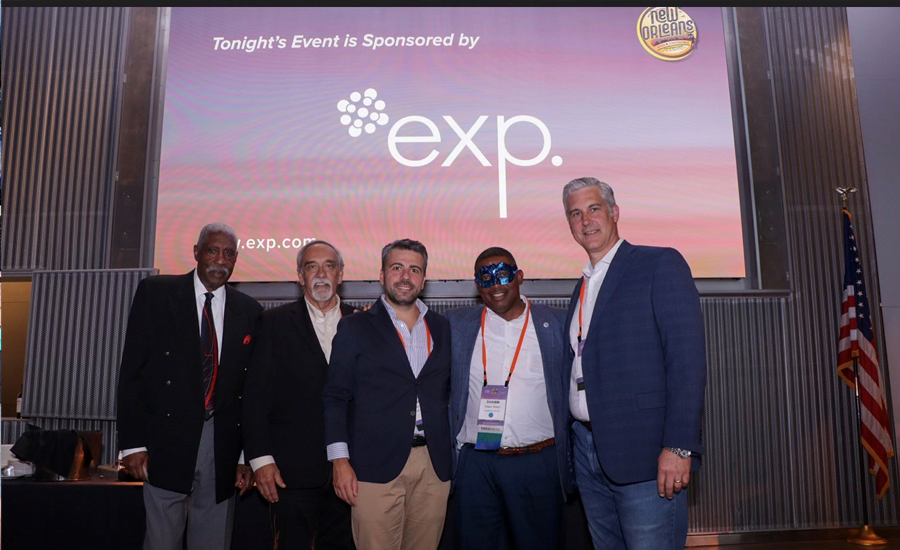 A group of men posing for a picture in front of a screen.