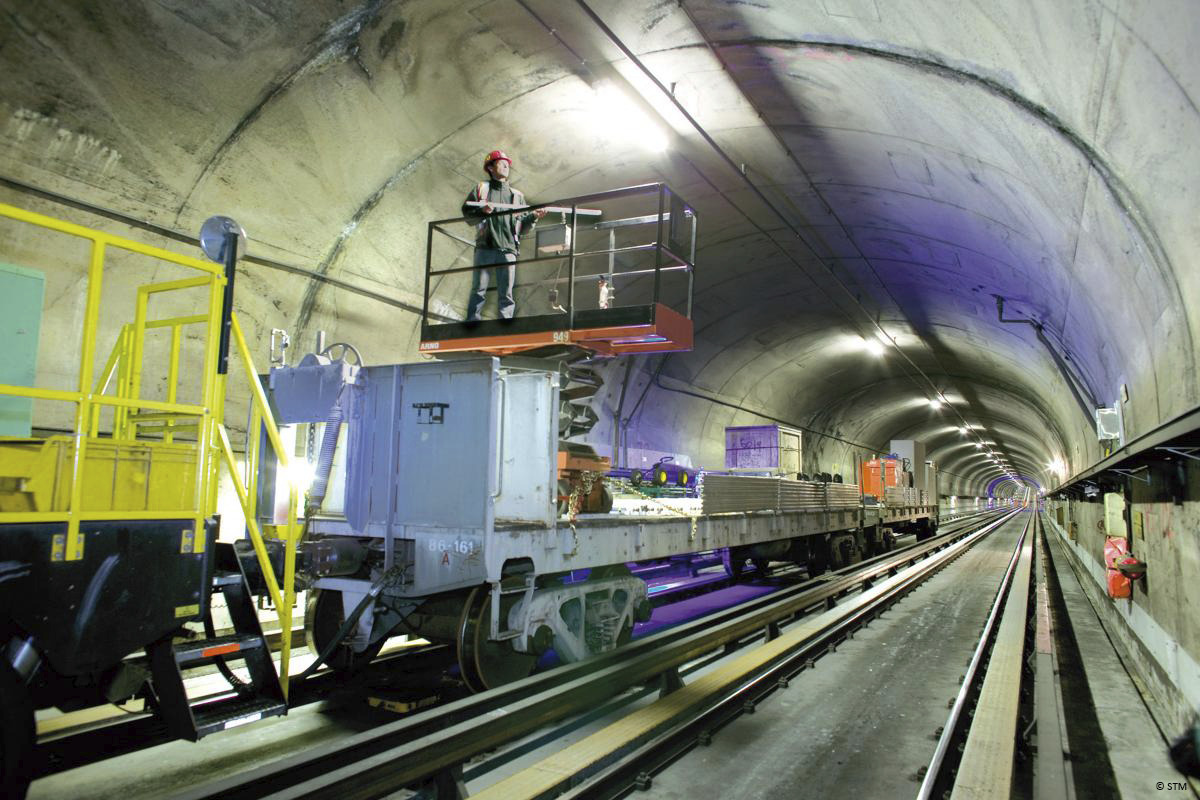 A man standing on a train in a tunnel.