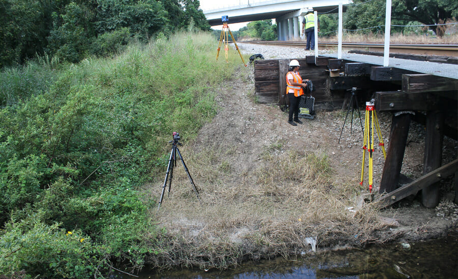 A group of workers standing on a bridge.