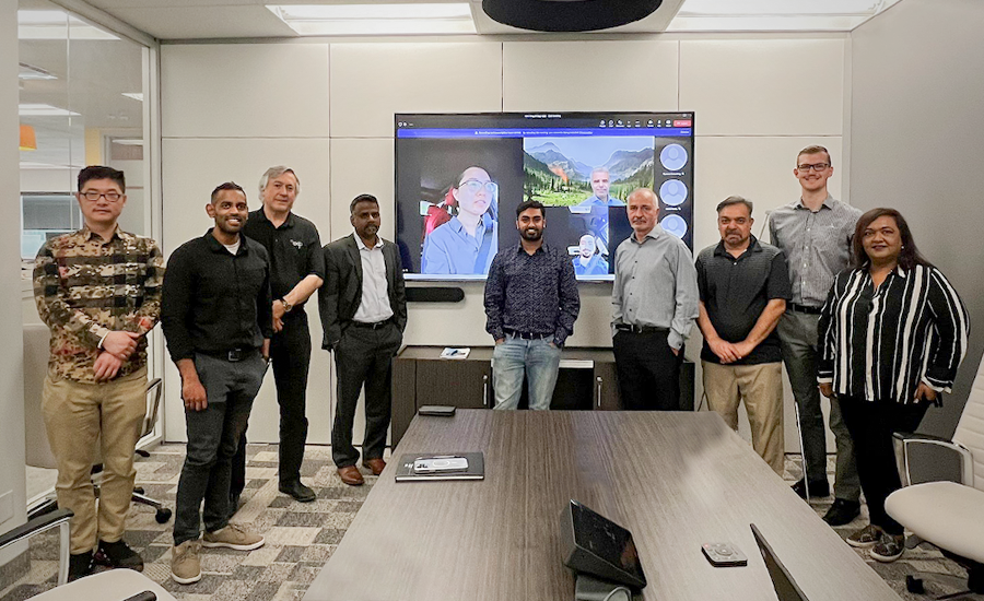 A group of people standing in a conference room, wearing Iron Rings.