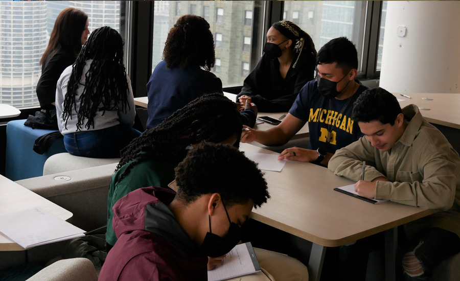 A group of people sitting at a table in a classroom.