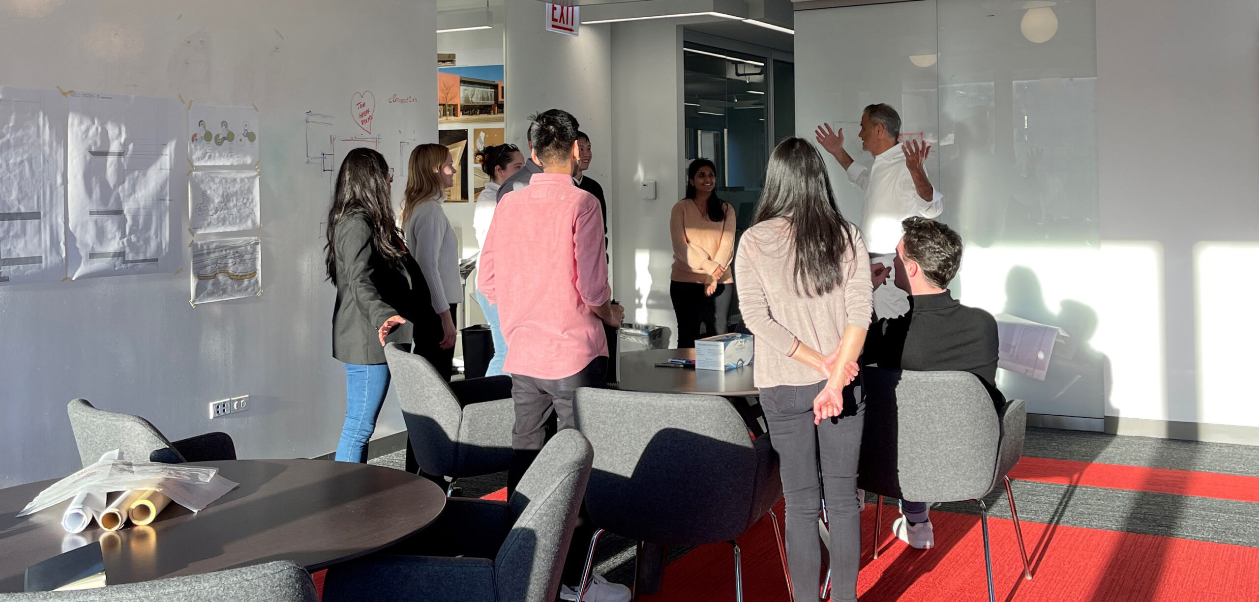 A group of people sitting around a table in an office.