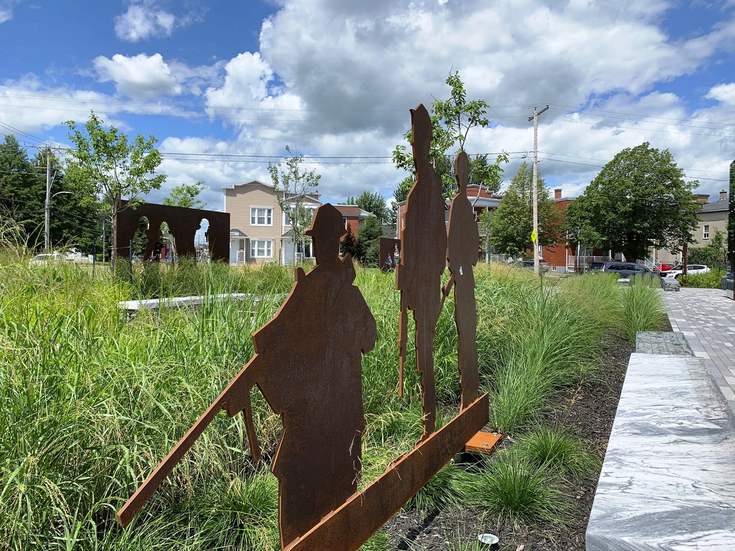 A group of metal sculptures in a grassy area.