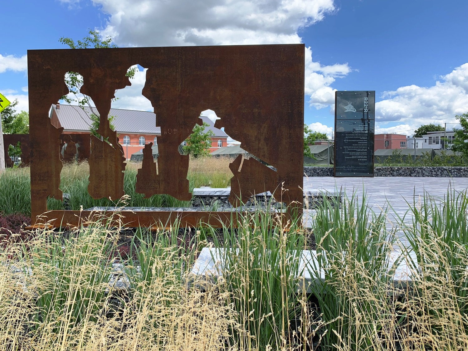 Une sculpture en métal se trouve au milieu d’une zone herbeuse.