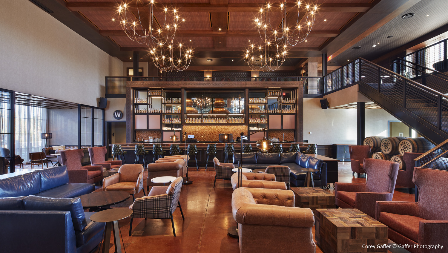 A large lobby with couches, chairs, and a staircase.