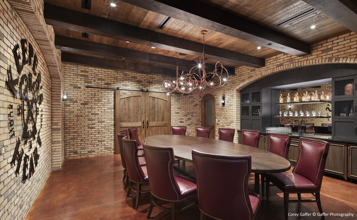 A dining room with a brick wall and red leather chairs.