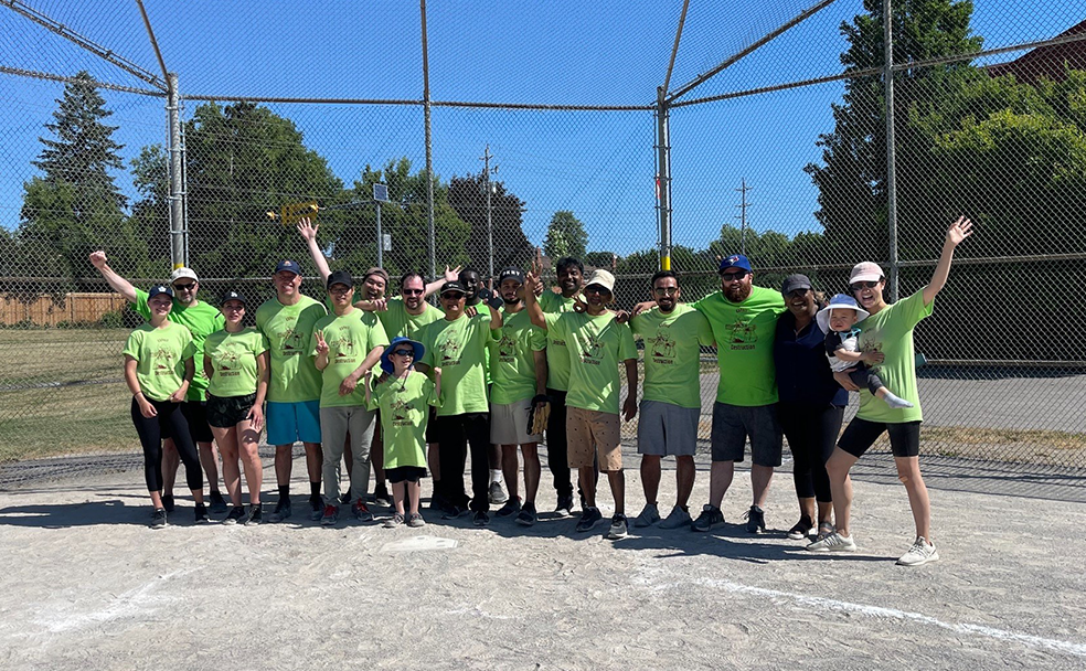 A group of people in green shirts posing for a photo.