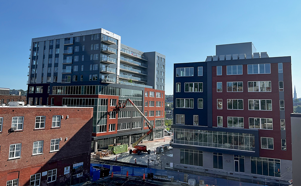 A view of a construction site with several buildings in the background.