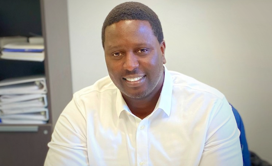 A man in a white shirt smiling at the camera.