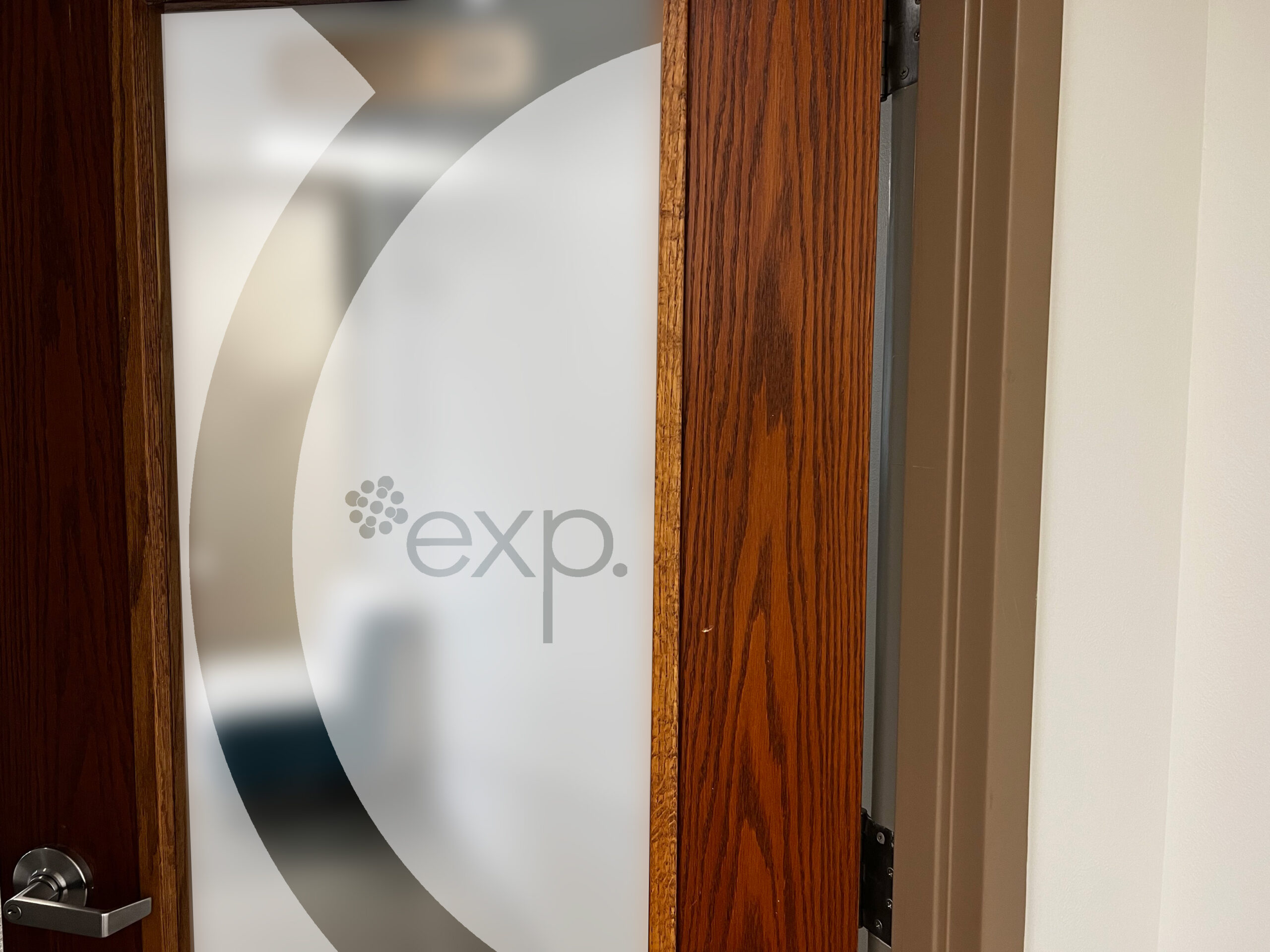 The EXP logo etched on the glass on an office door.