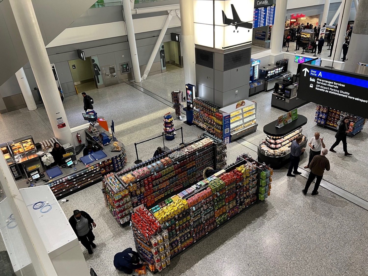 A view of a large airport terminal with people walking around.