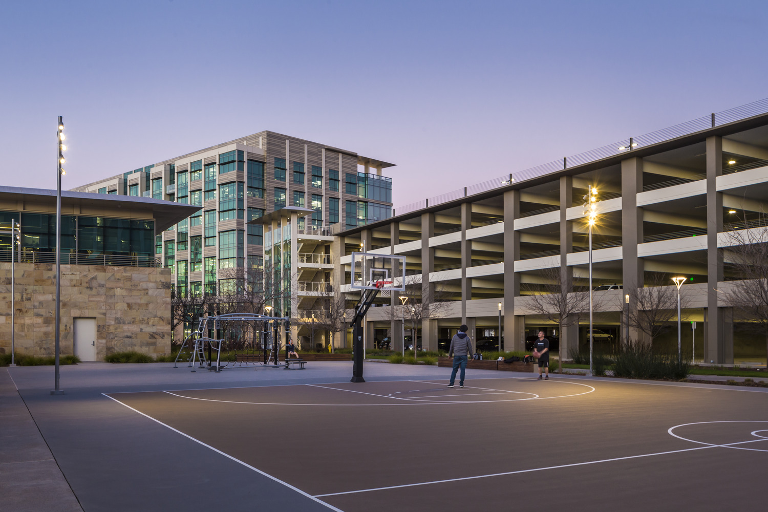 A basketball court in front of a building.