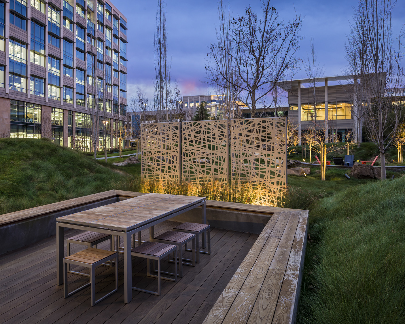 Une table et des chaises en bois dans une zone herbeuse.