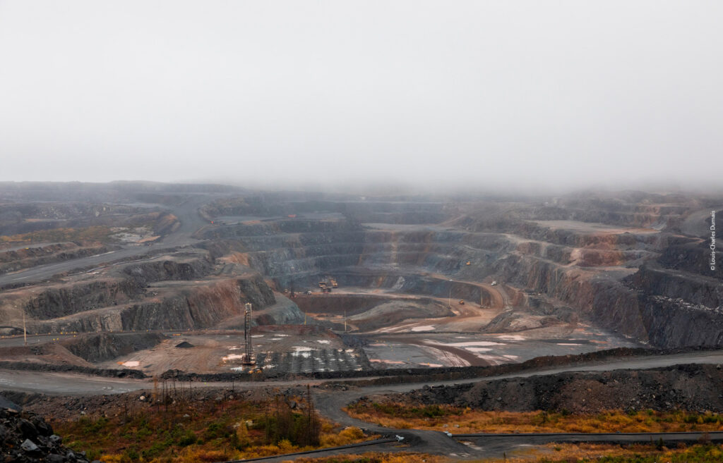 A view of an open pit mine on a foggy day.