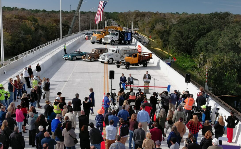 A crowd of people standing on a bridge.