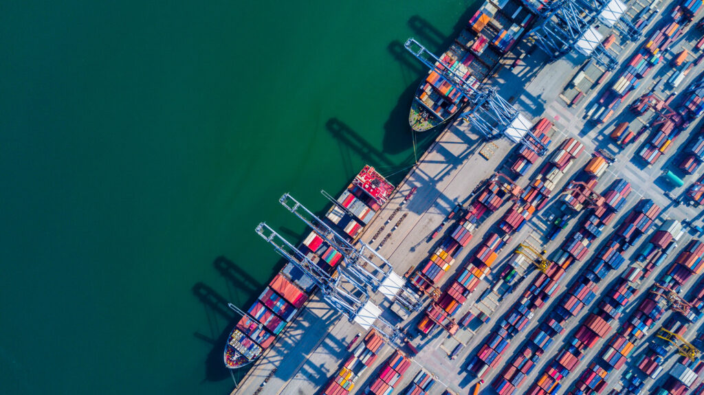 An aerial view of container ships docked at a port.