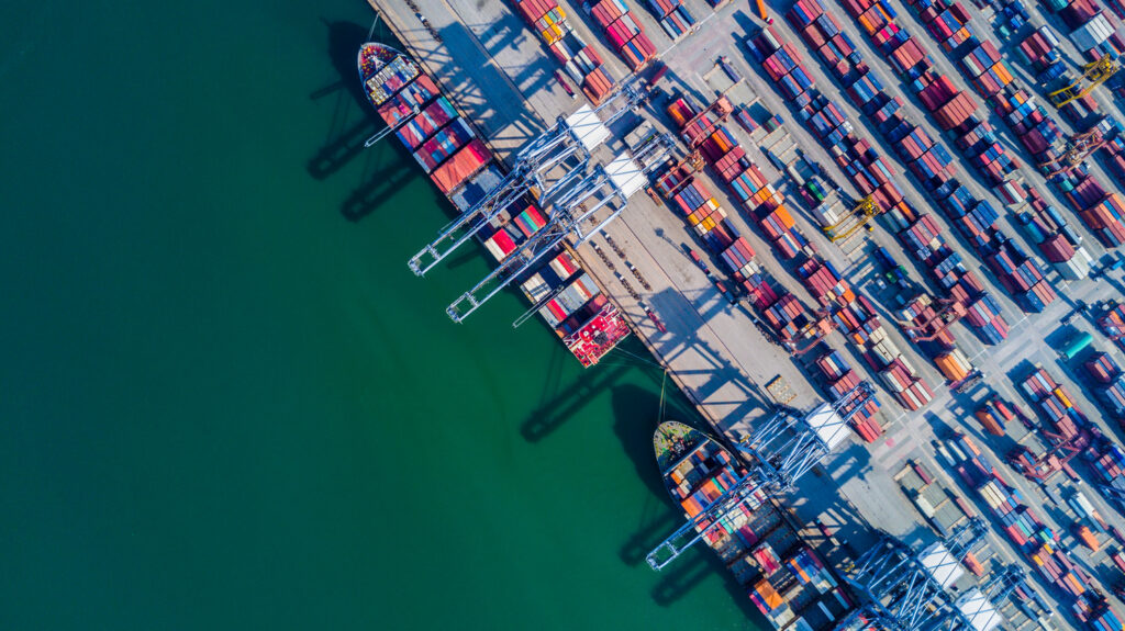 An aerial view of container ships docked at a port.