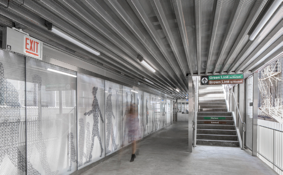 A woman is walking down a hallway in a subway station.