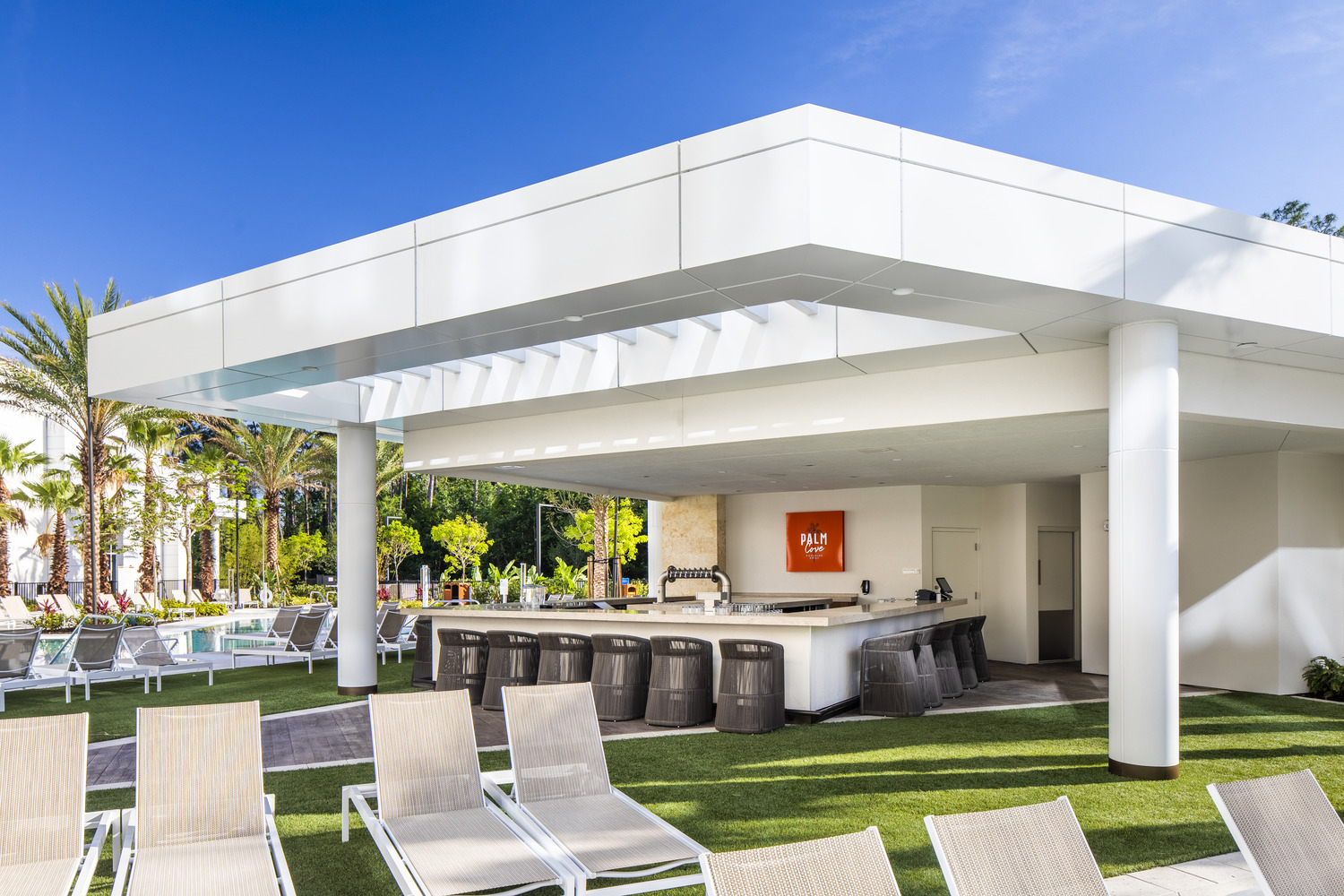 A pool area with lounge chairs and umbrellas.