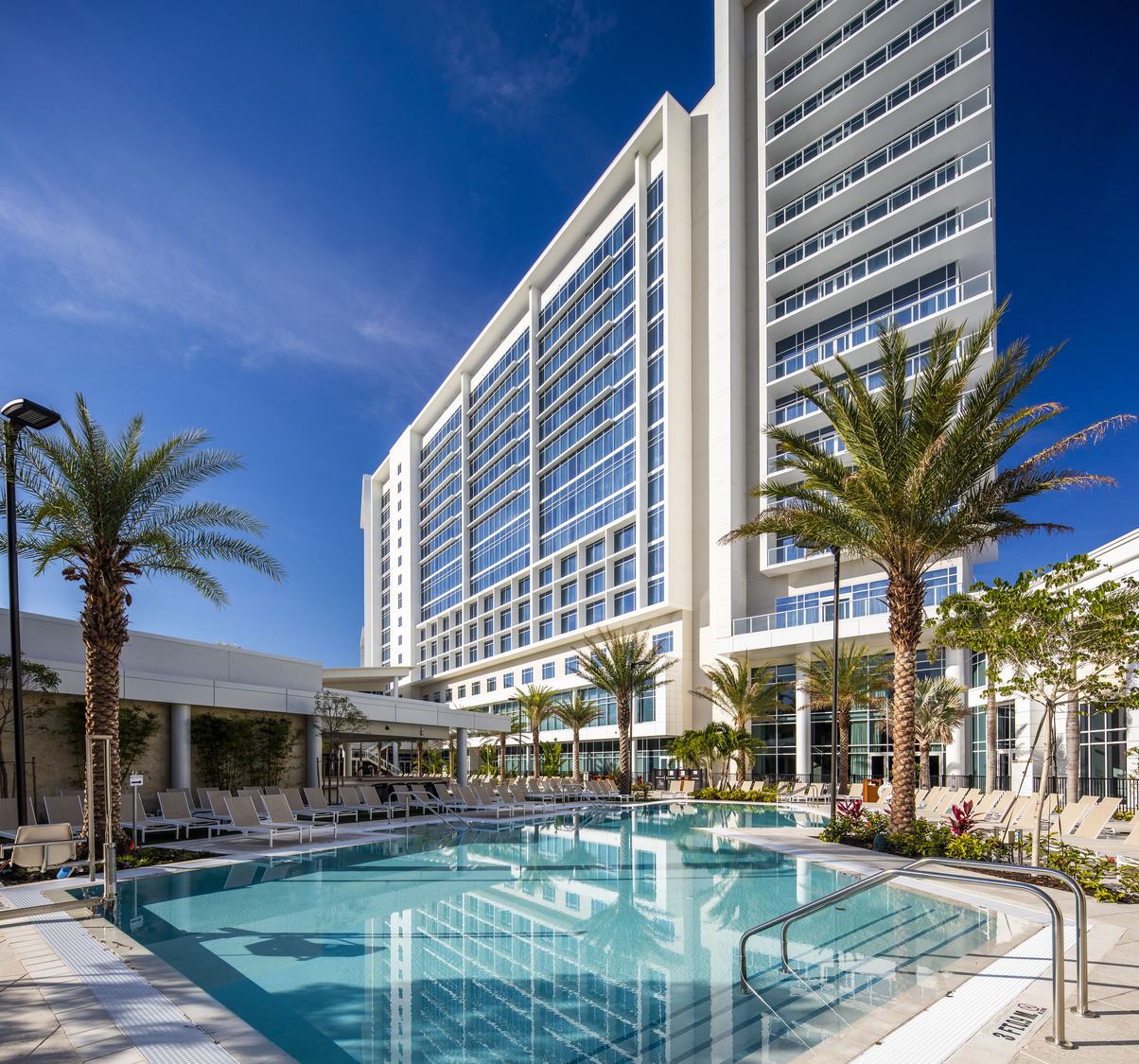 A swimming pool in front of a hotel.