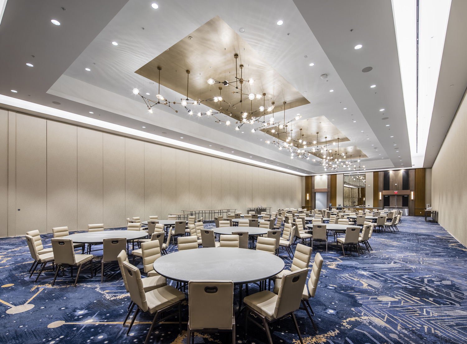 Une grande salle de conférence avec tables et chaises.