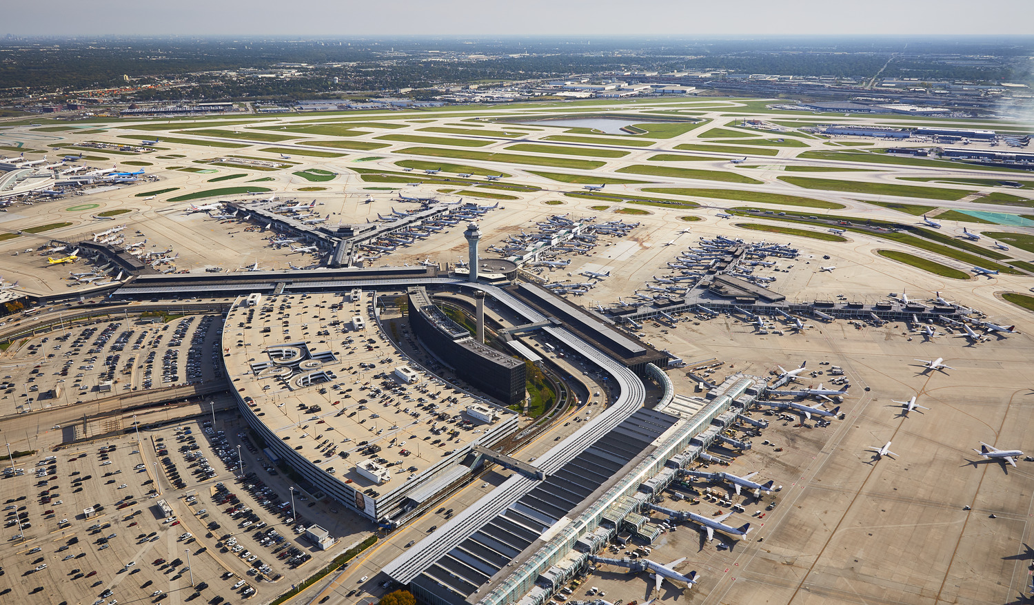 Aerial view of a busy airport with multiple runways and parked aircraft.