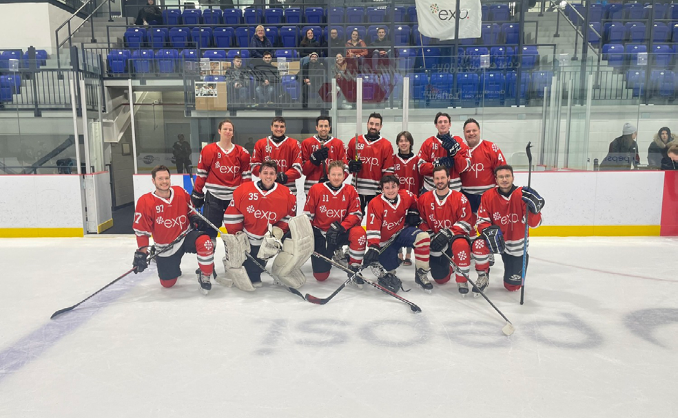 Une équipe de hockey pose pour une photo sur une patinoire.