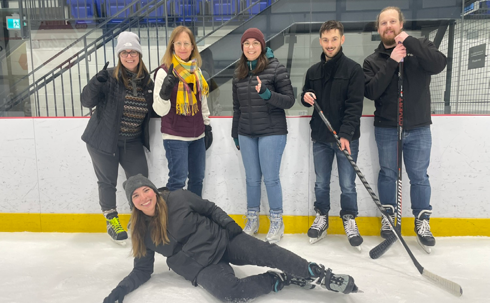 Un groupe de personnes posant pour une photo sur une patinoire.