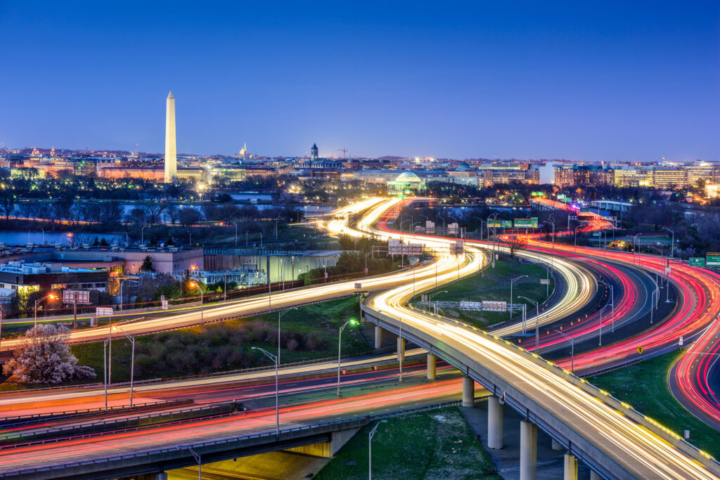 Twilight view of washington d.c. with illuminated roads, washington monument and capitol visible, highlighting busy traffic and urban infrastructure.