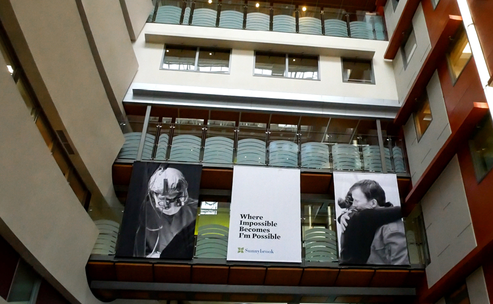 Intérieur d'un atrium avec balcons comportant de grandes banderoles, dont le texte : « Là où l'impossible devient possible, je suis possible.