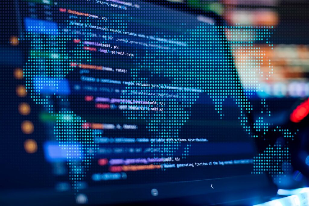 Digital map overlaying computer code on a screen, symbolizing global connectivity and technology.