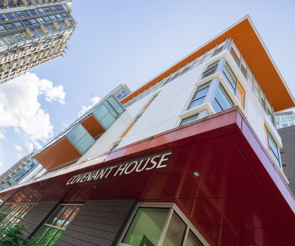 A modern multi-story building with a red awning labeled 