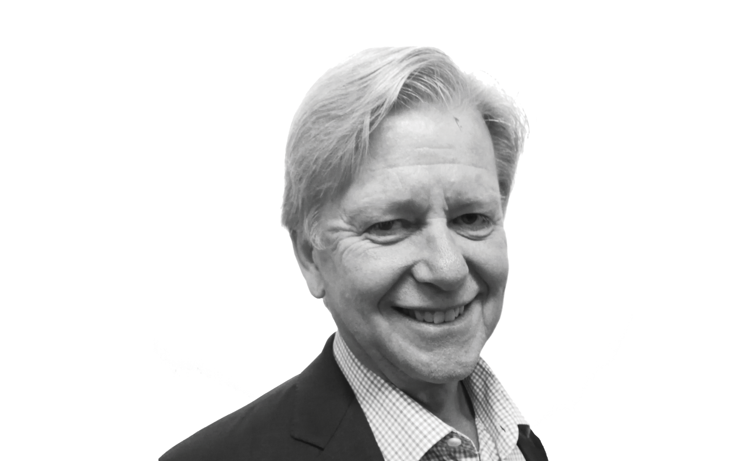 Smiling older man with light hair, wearing a dark blazer and checkered shirt, posed against a plain white background.